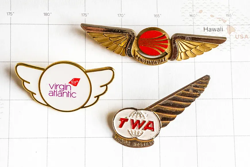 Three airline wing pins on a map.